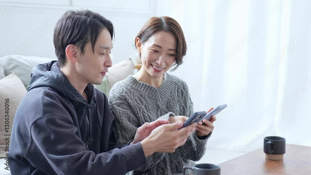 携帯を見るカップル 携帯を見るカップル