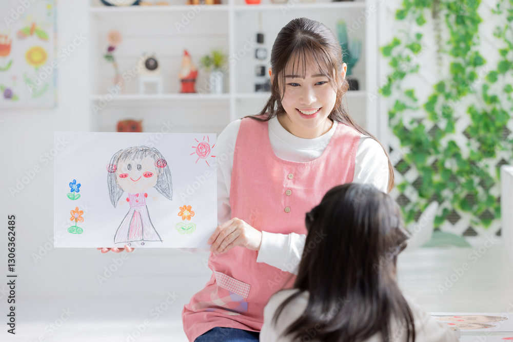 似顔絵を持つ保育士
似顔絵を持つ保育士