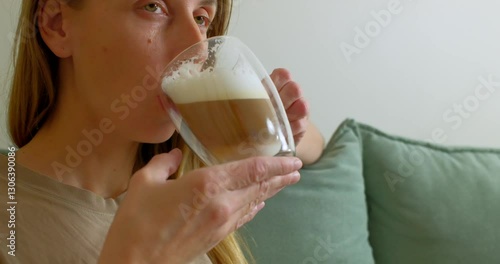 Woman Enjoying a Latte at Home on a Cozy Sofa photo