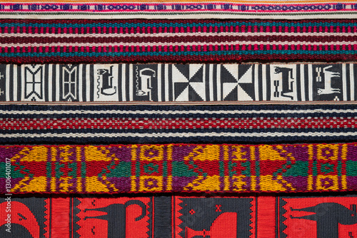 Close-up of traditional Andean woven textiles with intricate geometric and animal patterns in vibrant colors. Ideal for cultural heritage, craftsmanship, and textile design themes.