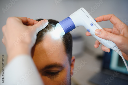 Принти на полотні A trichologist examines the hair of a man who begins alopecia