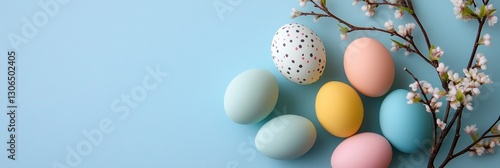 A colorful assortment of eggs are arranged on a blue background. The eggs are of different colors, including blue, yellow, and pink. The arrangement of the eggs creates a cheerful and festive mood