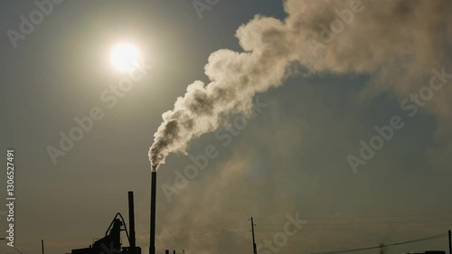 Description: Thick smoke rising from a factory chimney, symbolizing industrial pollution and its environmental impact.