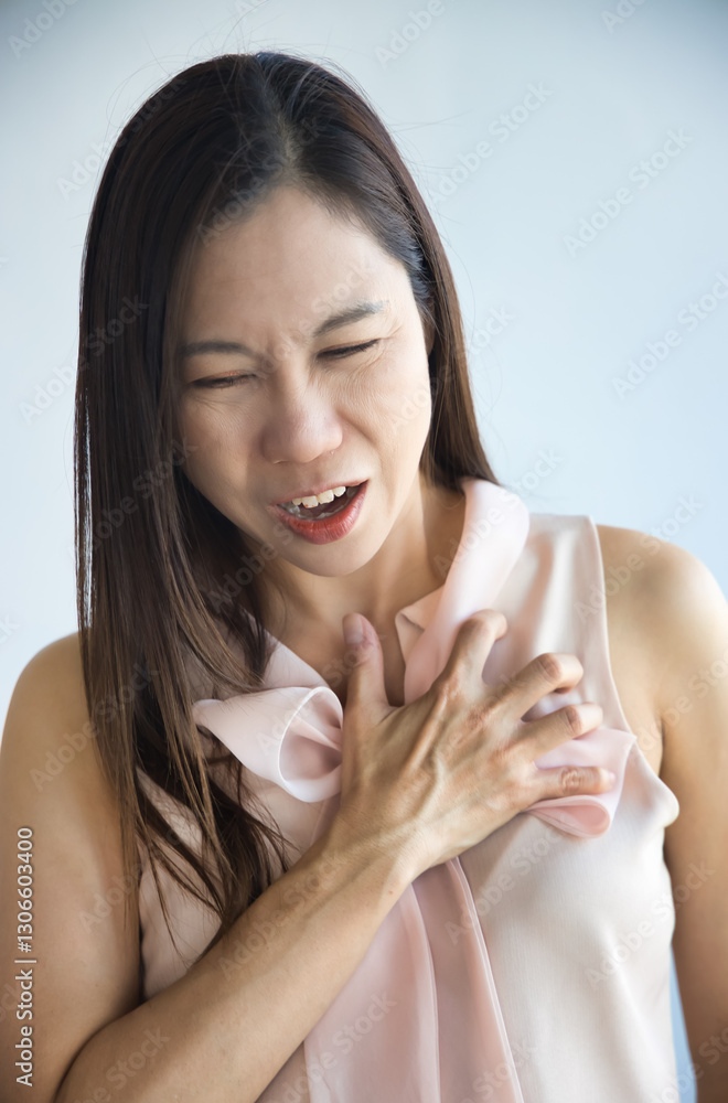 Unwell Asian woman suffering from heart condition, heart attack, irregular heartbeat Unwell Asian woman suffering from heart condition, heart attack, irregular heartbeat