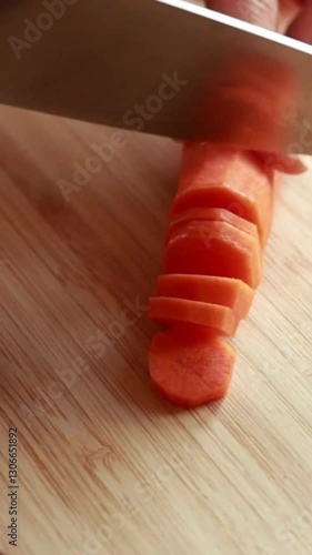  woman hands slicing carrot on wooden board close-up