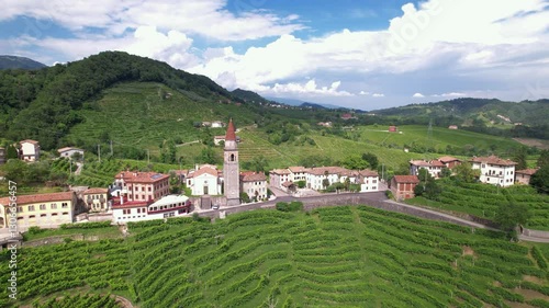 DRONE FOOTAGE: Famous Prosecco Hills in Veneto wine region. View of vineyard Prosecco and the Chiesa di Rolle church in Rolle, a small hamlet of Cison di Valmarino, Valdobbiadene, Veneto, Italy.