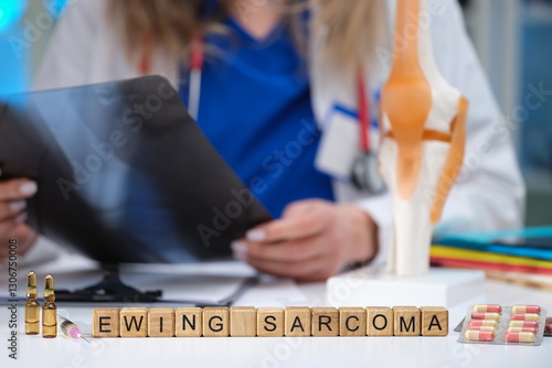 A dedicated healthcare professional thoroughly reviews Ewing Sarcoma related educational materials and anatomy models photo