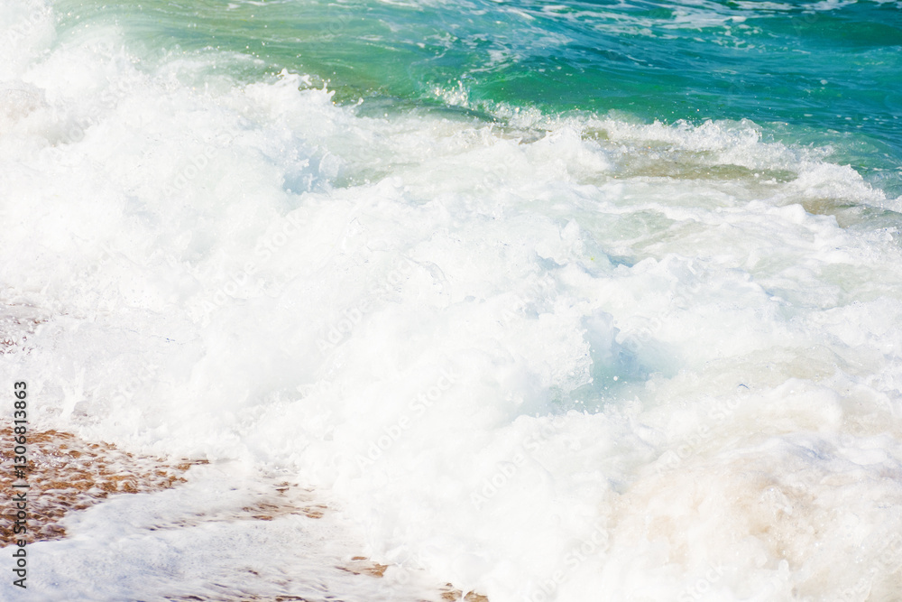 sea foam on the sandy beach. wet sand. closeup nature background on a sunny afternoon. summer vacation season. turquoise water