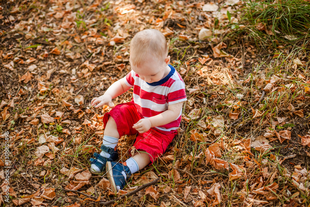One-year-old little boy exploring the world in an autumn forest One-year-old little boy exploring the world in an autumn forest