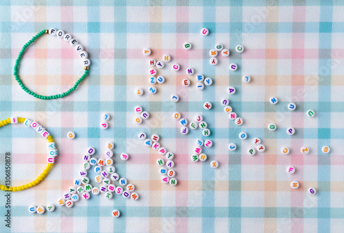 Handmade bracelet with letter beads. Flat lay, top view.