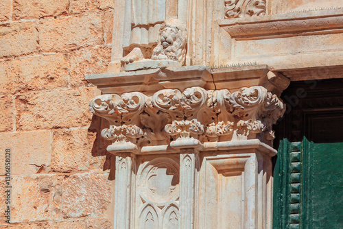 Obraz na płótnie Intricately carved stone column and archway, detailed floral and scrollwork designs, sculpted lion figure at the top. Craftsmanship and ornate details suggest historical or architectural significance w salonie