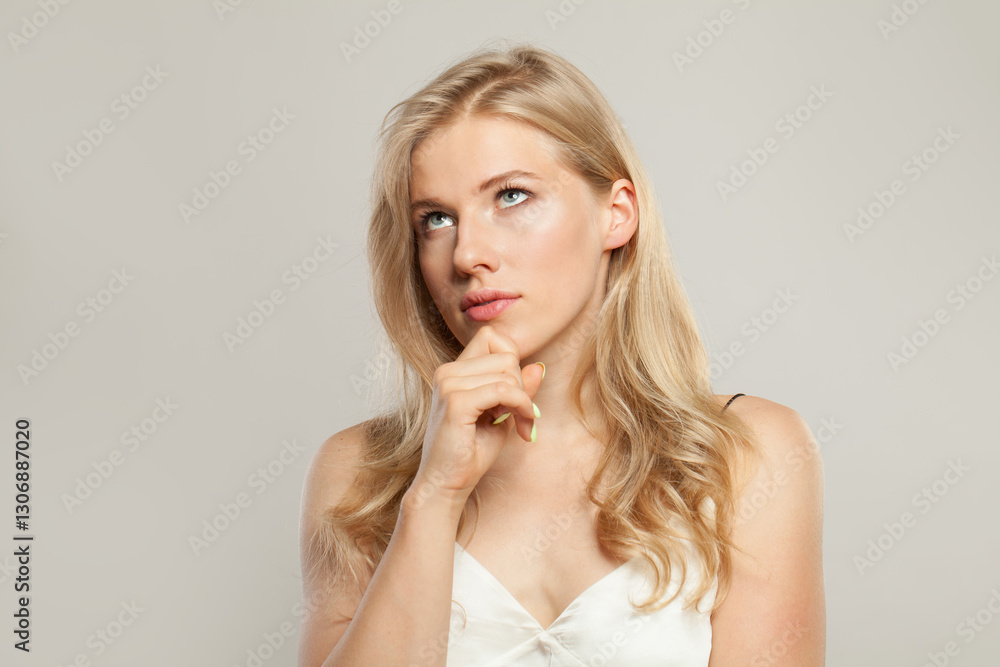 Thinking blond model woman portrait. Beautiful face with healthy clear skin, long shiny hair and cute smile