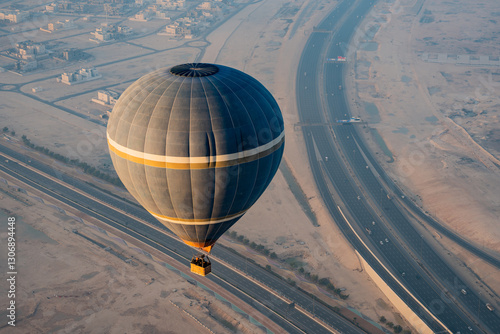 Balon na ogrzane powietrze lecący nad autostradą i miastem