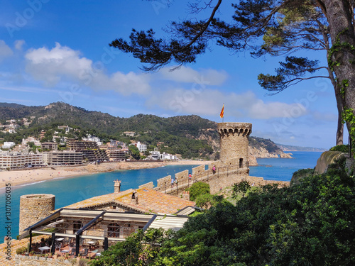Picturesque view of medieval city walls and fortification. Mediterranean Sea shore, turquoise water, beach and tourist resort. Tossa de Mar, Costa Brava, Catalonia, Spain
