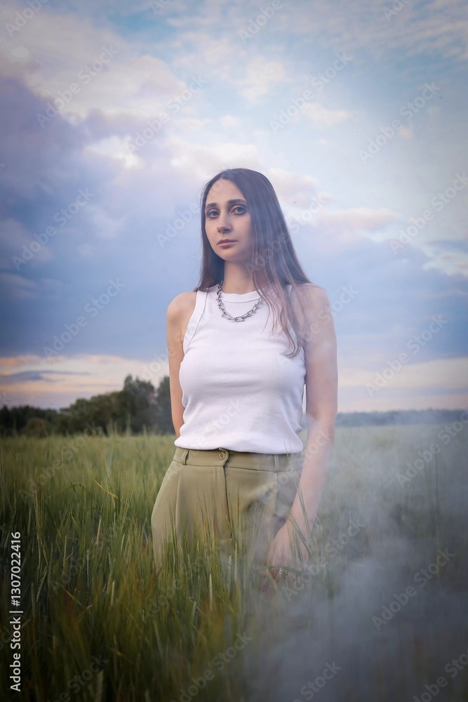 Beautiful girl in the field.  Spring/Summer photo. Summer style, shades of clothes match the color of the environment.