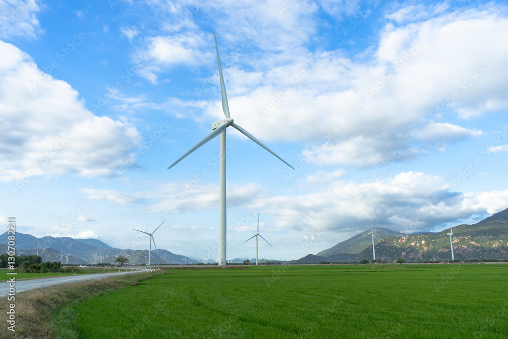 Wind turbines generating electricity on rice field at Phan Rang, Ninh Thuan, Vietnam. Clean energy concept. Windmill for electric power production Wind turbines generating electricity on rice field at Phan Rang, Ninh Thuan, Vietnam. Clean energy concept. Windmill for electric power production