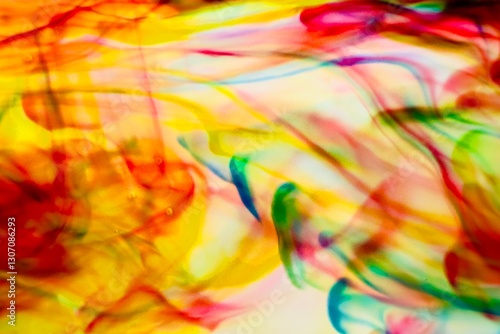 Abstract video with vibrant colors flowing with colored inks dispersed in water. The composition consists of shades of blue, red, green and yellow blending and swirling on a light background, creating