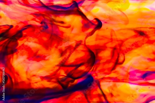 Abstract video with vibrant colors flowing with colored inks dispersed in water. The composition consists of shades of blue, red, green and yellow blending and swirling on a light background, creating