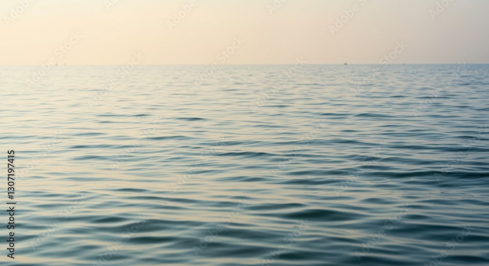 Obraz premium Serene ocean waves gently lapping against the shore during sunset, with a calm horizon