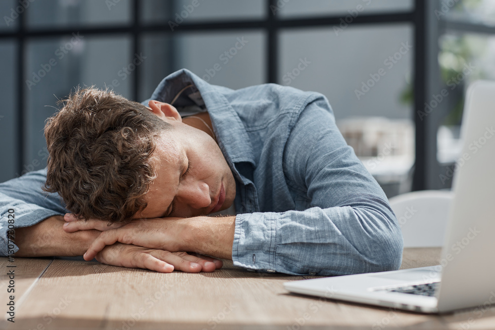 young office man at a laptop sleeping at his workplace young office man at a laptop sleeping at his workplace