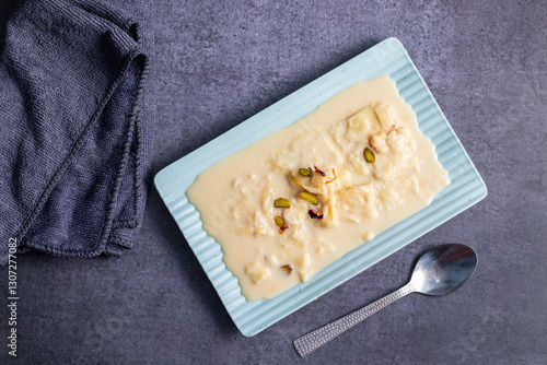 Rabdi is a rich, creamy Indian dessert made by slow-cooking milk until thick, then sweetened with sugar, flavored with cardamom, and garnished with nuts. photo