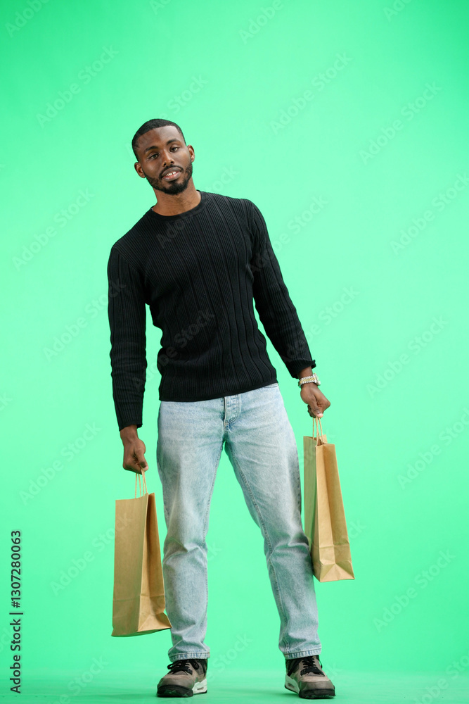 A man, full-length, on a green background, with bags A man, full-length, on a green background, with bags
