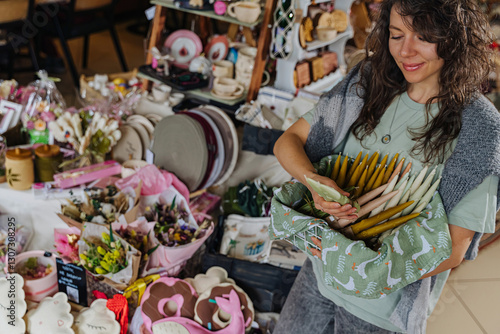 Wallpaper Mural Artisan organizing handcrafted decor at a market stall.  Colorful handmade candles, flowers, and decor at craft fair. Torontodigital.ca