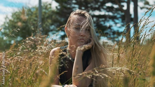 Young BBlond-Haired Women Sitting in the Filed of Tall Grass and Her Hair Blowing by the Wind in Slow Motion 4K Footage