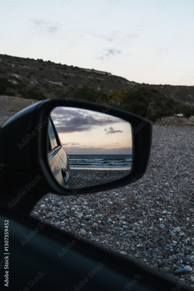 Beach scene is reflected in the side mirror of a parked car, capturing the ocean waves and evening sky Beach scene is reflected in the side mirror of a parked car, capturing the ocean waves and evening sky