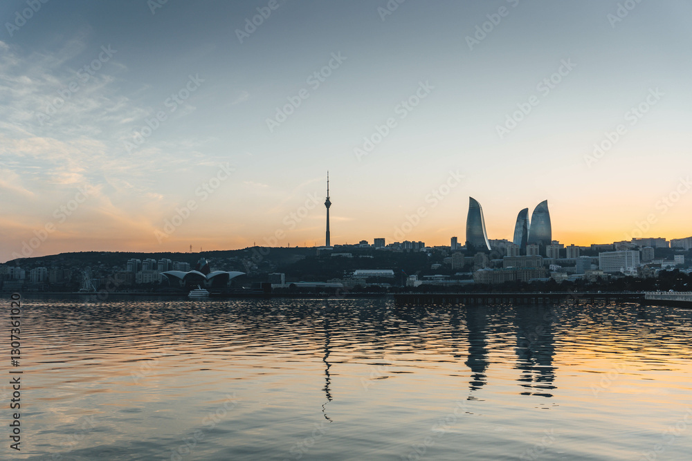 Naklejka premium top panoramic view of baku city with huge area with buildings flame towers symbol on sunset golden light and water reflections