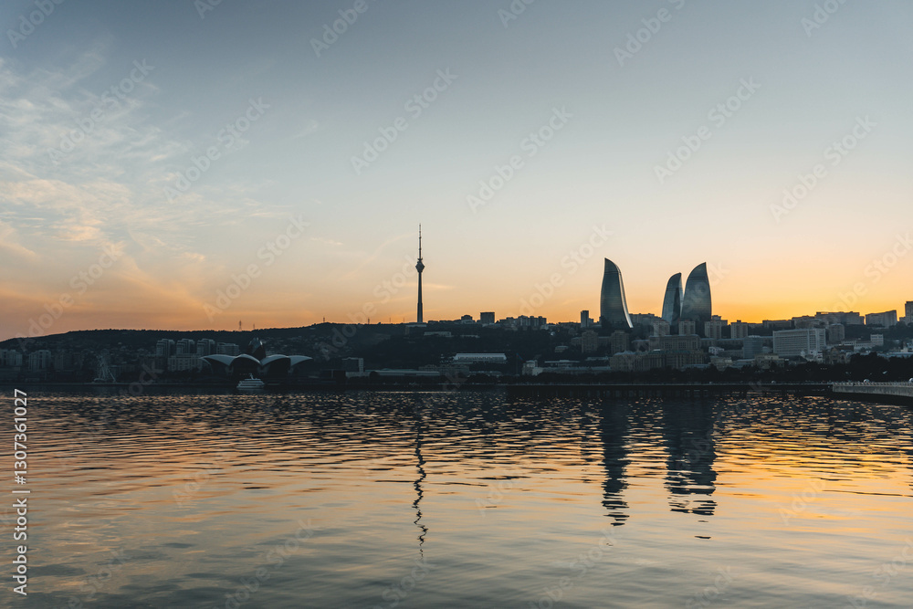 Naklejka premium top panoramic view of baku city with huge area with buildings flame towers symbol on sunset golden light and water reflections