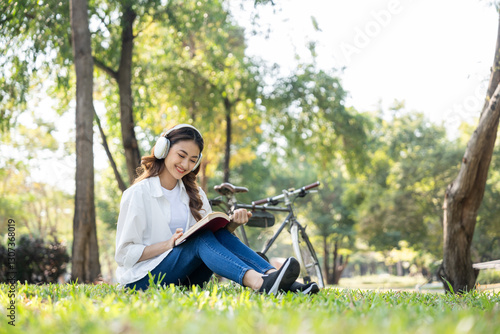 Young asian woman relaxing reading book sitting at public park life style outdoor. Happy female Take a break enjoy time living in the nature. Human and nature together