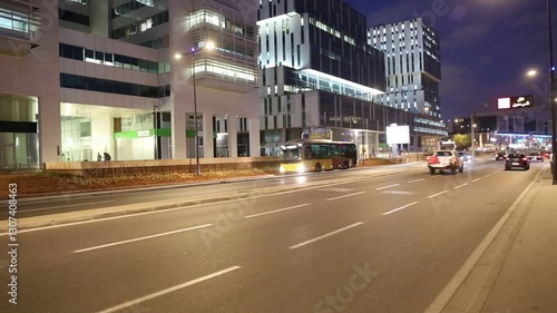 Modern houses and skyscrapers in Casablanca at night. Frantic rhythm of city. Traffic on the night highway. Morocco