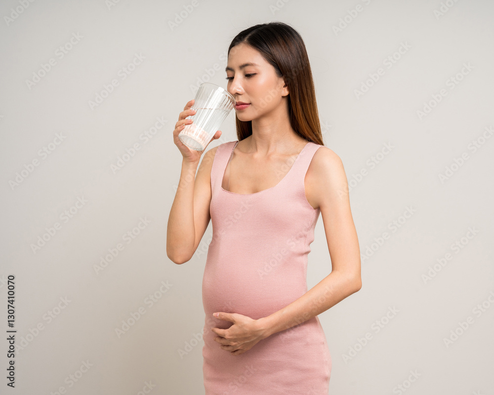 Happy Pregnant asian woman stroking touch belly motherhood drinking milk on isolated background. Family planning maternity and pregnancy with insurance for child health. Happy Pregnant asian woman stroking touch belly motherhood drinking milk on isolated background. Family planning maternity and pregnancy with insurance for child health.