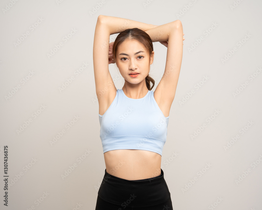 Young beautiful smiling asian woman with sportswear stretching arm warming up before training. Happy healthy slim fit and firm latin attractive sporty woman standing pose exercise workout in studio. Young beautiful smiling asian woman with sportswear stretching arm warming up before training. Happy healthy slim fit and firm latin attractive sporty woman standing pose exercise workout in studio.