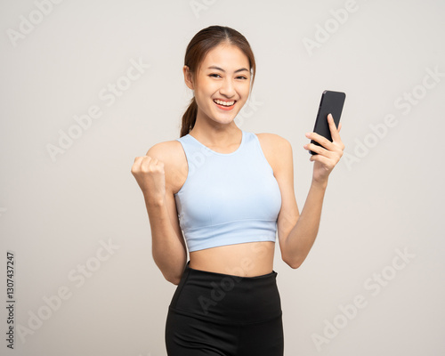 Young beautiful asian woman with sportswear using smartphone on isolated white background. Attractive Portrait latin sporty woman standing pose holding cell phone exercise workout in studio.