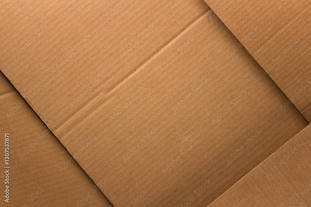 close up of brown corrugated cardboard, with creases and folds visible, creating a textured background.