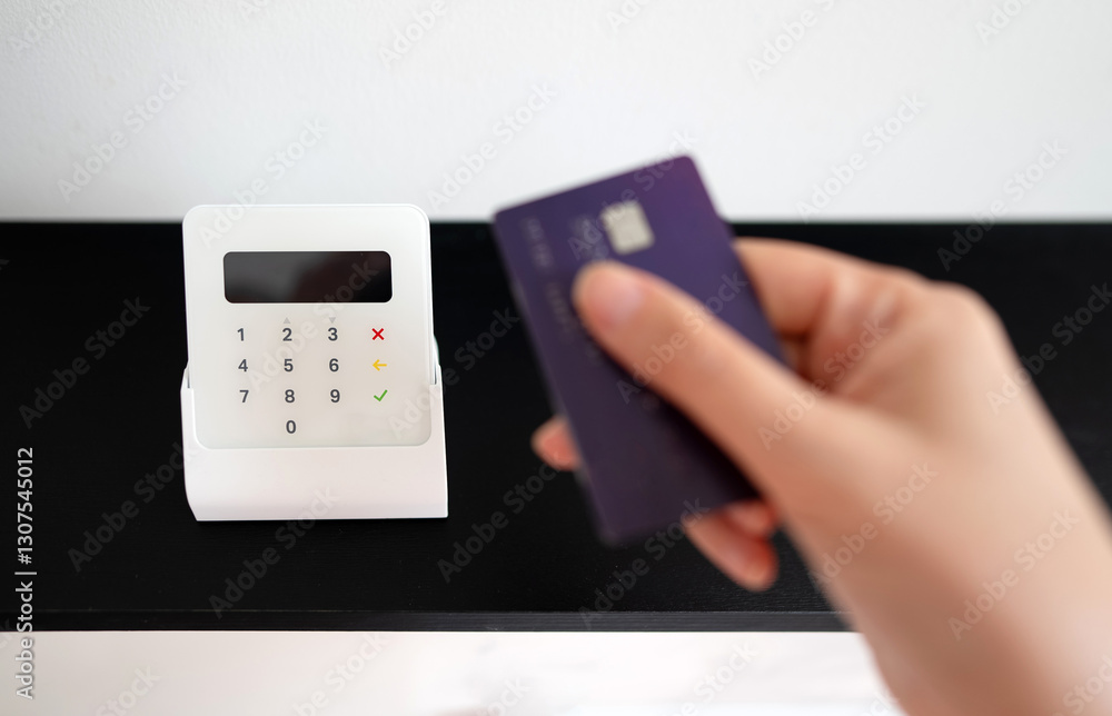 Woman's hand making a contactless payment with a card on a wireless terminal. Woman's hand making a contactless payment with a card on a wireless terminal.