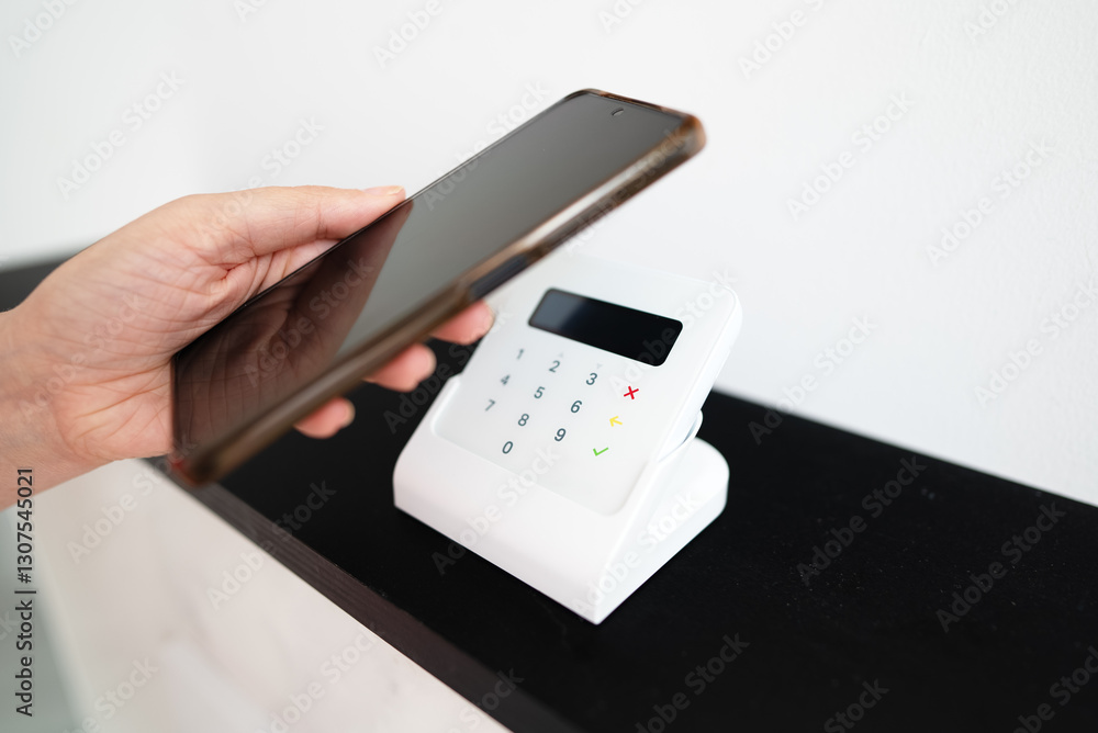 Woman's hand making a contactless payment with a phone. Woman's hand making a contactless payment with a phone.