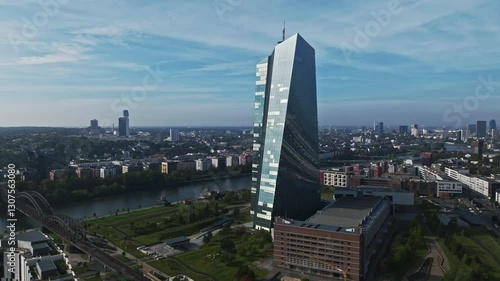 Aerial Drone View of the European Central Bank (Europäische Zentralbank), Located Along the Main River in Frankfurt, Germany – Striking Glass and Steel Skyscraper with a Unique Twisted Design, Standin