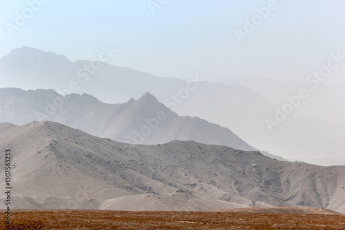 Serene Desert Landscape With Layered Mountains and Dry Terrain Under a Clear Sky, Cabul, Afganistan photo