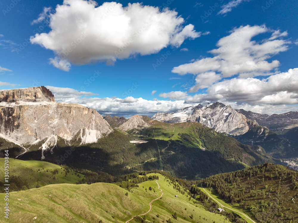 Naklejka premium Beautiful Dolomite mountain Alps dawn aerial view range against blue sky on sunny day Italy. Top view drone of high rocks, mountain peaks. Tourism travel concept. Amazing nature scenery in Dolomites