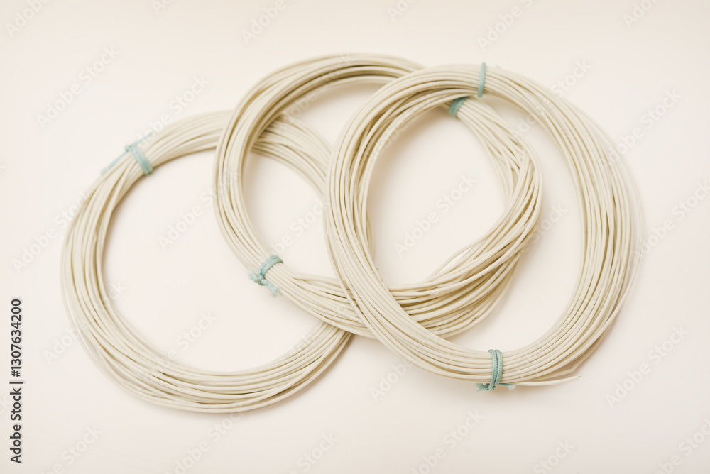 Twists of mounting wires on a white background. White wires of electronics. Twists of mounting wires on a white background. White wires of electronics.