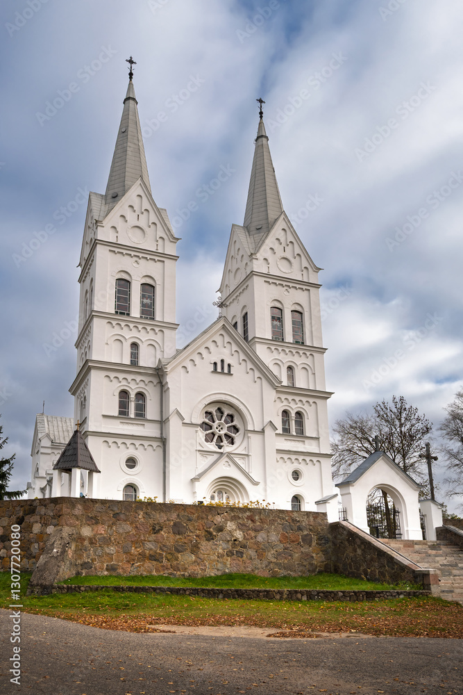 Church of the Sacred Heart of Jesus in Slobodka, Braslav Lakes, Belarus. A white neo-Gothic Catholic church with two tall spires, arched windows, and intricate detailing. Church of the Sacred Heart of Jesus in Slobodka, Braslav Lakes, Belarus. A white neo-Gothic Catholic church with two tall spires, arched windows, and intricate detailing.
