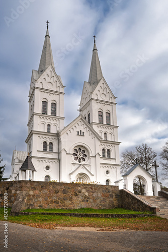 Church of the Sacred Heart of Jesus in Slobodka, Braslav Lakes, Belarus. A white neo-Gothic Catholic church with two tall spires, arched windows, and intricate detailing. photo