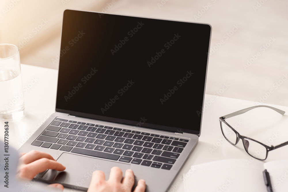 Online conference during work. Young man holds hands on laptop and looks in monitor at workplace, free space Online conference during work. Young man holds hands on laptop and looks in monitor at workplace, free space