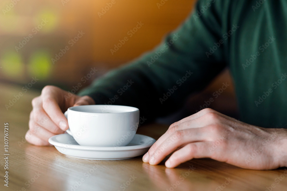 Cropped of man hands holding cup of coffee, cafe interior Cropped of man hands holding cup of coffee, cafe interior
