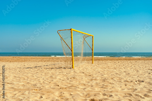 Beach soccer goal, blue sky, summer sport.