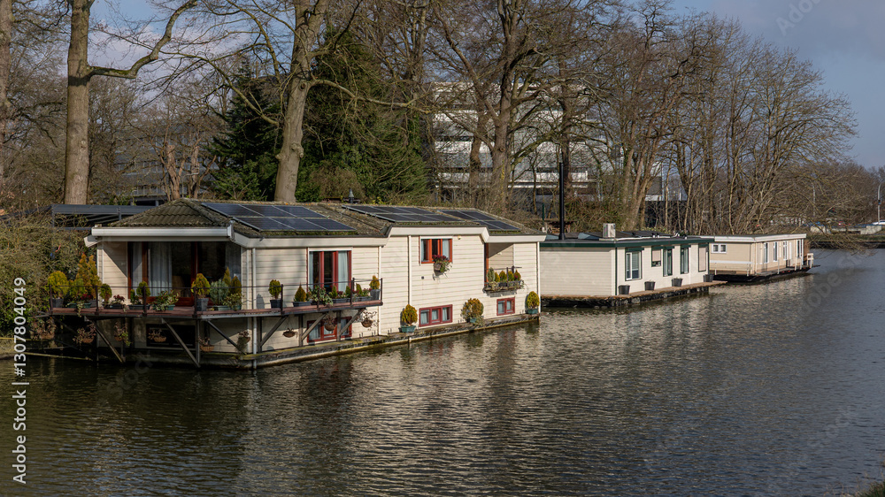 Floating houseboats on a canal in the Hanseatic city of Zwolle in Overijssel, a typical image of houseboats on the canals in the Netherlands Floating houseboats on a canal in the Hanseatic city of Zwolle in Overijssel, a typical image of houseboats on the canals in the Netherlands