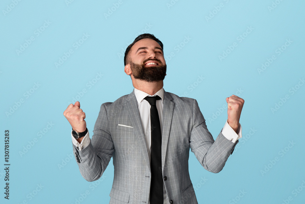 Victory and success. Handsome businessman feeling excited and gesturing YES against blue background Victory and success. Handsome businessman feeling excited and gesturing YES against blue background